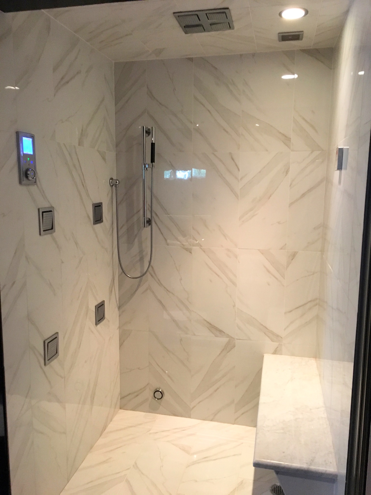 Marble steam shower with Kohler DTV+ digital touchscreen control and floating bench, Westchester County