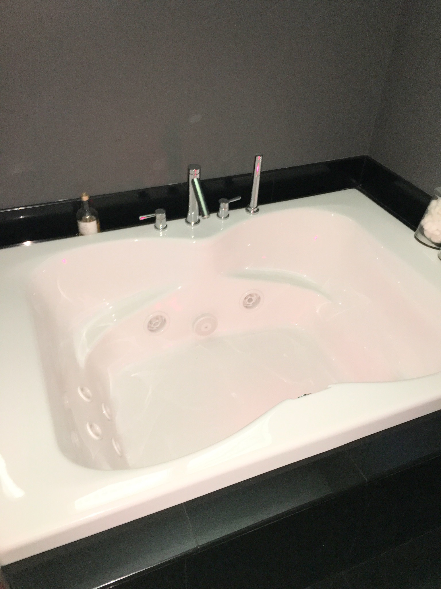 Two-person whirlpool soaking tub set in black granite surround, Westchester County